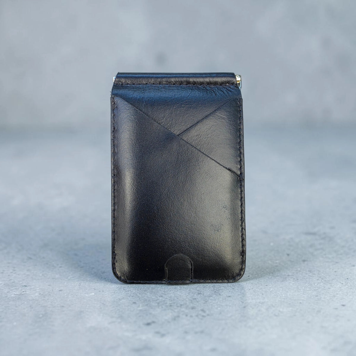 Billetera clip de cuero negro con diseño cruzado, vista frontal